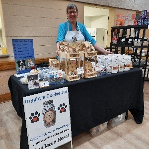 Rose behind her vendors table with all of her products